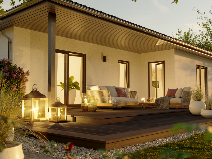 Nahaufnahme der Holzterrasse des Winkelbungalow 108 bei Dämmerung mit stilvoller Möblierung und sanfter Gartenbeleuchtung.